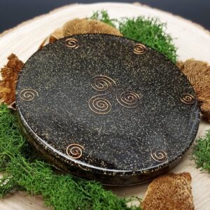 orgonite oplaadschijf zwart rond met koperen triskelion en spiralen